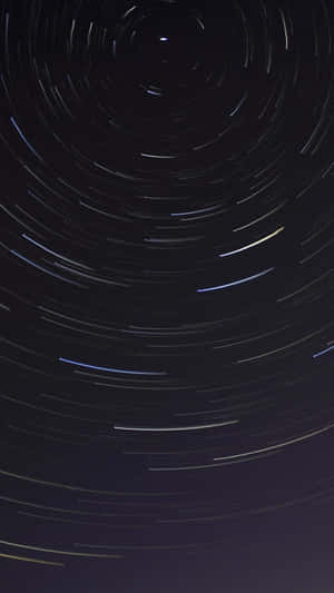 星軌在夜空中盤旋，上演一場迷人的宇宙之舞。 — iPhone 7 壁紙