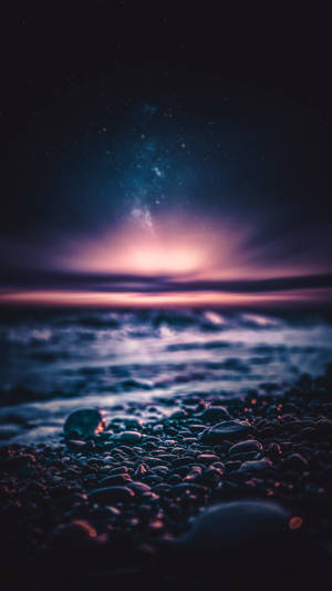 繁星點點的夜空下，鵝卵石海灘與溫柔的海浪。 — 沙灘 壁紙
