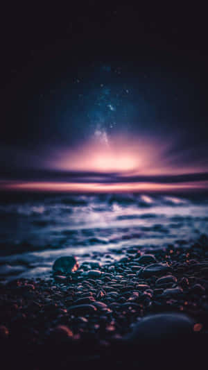卵石灘上的繁星夜空，閃爍的銀河與輕柔的海浪。 — 月色夜空 壁紙