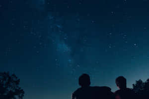 兩個人以星空為背景的剪影，銀河可見 — 星星 壁紙
