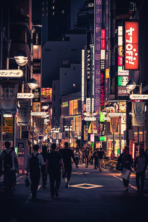 夜晚東京嘅霓虹燈街道，有行人同發光嘅招牌。