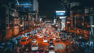 夜晚的城市街道，擠滿汽車和發光的標誌。 — 夜景城市 壁紙