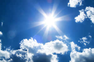 太陽在晴朗的藍天中透過散落的雲層明亮地照耀。