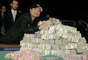 撲克玩家在錦標賽桌上以成堆的現金和籌碼慶祝勝利。 — 微笑 壁紙