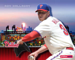 費城人隊投手 Roy Halladay 身穿費城人隊球衣，在夜晚的城市燈光背景下投球。 — 紐約市 壁紙