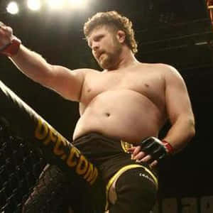 MMA拳手在UFC八角籠中高舉拳頭慶祝勝利。