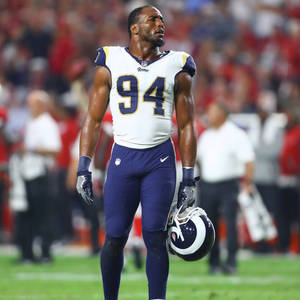 NFL球員94號拿著頭盔在球場上行走