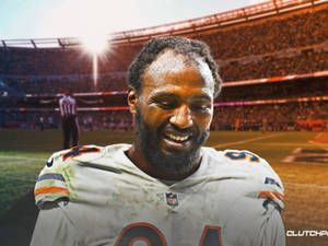 NFL足球運動員在日間比賽中穿著泥濘的制服在場上微笑。