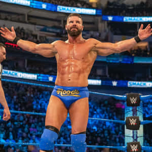 WWE摔角手Bobby Roode雙臂伸展，在摔角擂台上慶祝勝利。 — 摔角 GIF 壁紙