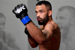UFC拳手戴黑色手套，手臂有紋身，擺出強烈姿勢 — 運動 壁紙