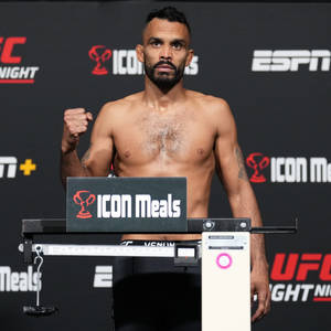 UFC拳手在稱重活動中站在體重磅上，帶有ESPN和ICON Meals標誌。