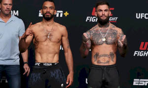兩名赤裸上身、有紋身的男性UFC拳手為稱重活動擺姿勢。
