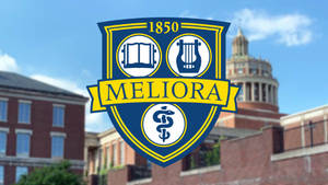 Meliora 大學徽章，帶有書本、豎琴和雙蛇杖，位於磚造建築上方