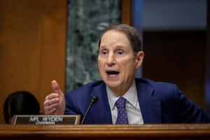 參議員羅恩·懷登在聽證會上穿著藍色西裝和領帶發言。