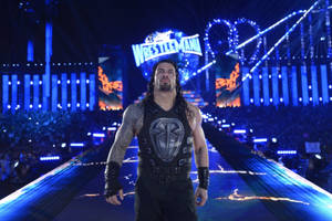 摔角手 Roman Reigns 在 WrestleMania 活動期間走在明亮的競技場斜坡上。