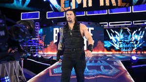 摔角手 Roman Reigns 在一個帶有相機和設備的明亮摔角舞台上。
