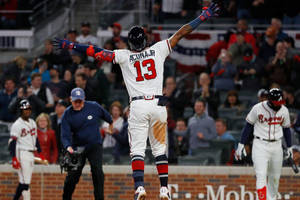 棒球選手阿庫尼亞 Jr. 擊出全壘打後高舉雙臂慶祝。