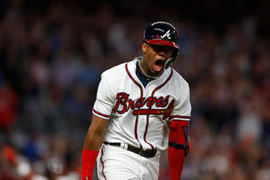 身穿Braves球衣的棒球手在夜間比賽慶祝勝利。