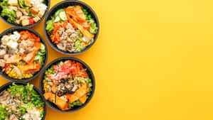 五個 poke 碗，在黃色表面上放有各種配料。