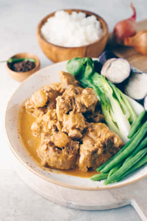 一盤咖喱配肉和綠色蔬菜，搭配米飯和洋蔥。 — Huawei MatePad 11.5 S (2025) 壁紙