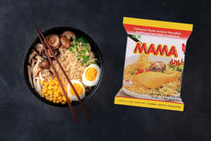 一碗Mama即食麵，配上配料和包裝，置於深色布料上。