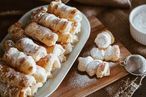 金黃色的奶油餡糕點撒上糖粉，放在木板上。