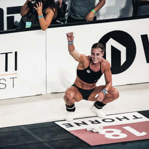 女性運動員舉起拳頭慶祝體育比賽勝利。