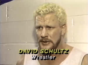 摔角手 David Schultz 在訪問中身穿白色背心。