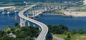 彎曲高速公路橋樑橫跨河流，有船隻和綠地