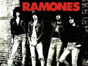Ramones樂隊成員穿著皮褸和牛仔褲，站在磚牆前。