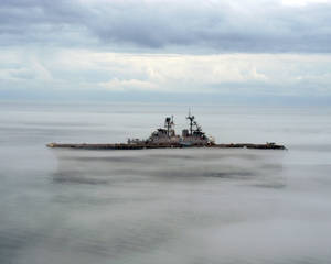在多雲的天空下，一艘軍艦部分被海霧遮蔽。 — 海 壁紙