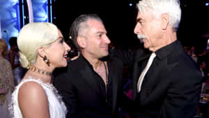Gaga 和 Tom Hanks 在一個正式的頒獎活動中微笑聊天。 — 電影 壁紙