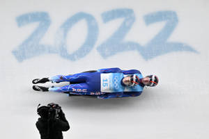 2022年冬奧會期間，兩名雪橇運動員在冰道上競速。