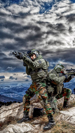 兩名身穿迷彩裝備的武裝士兵在山脊上瞄準步槍。