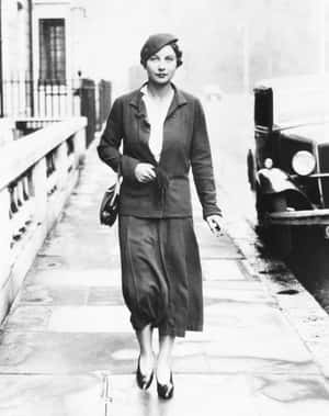 身穿1930年代服裝的女性在濕漉漉的人行道上走在老爺車旁 — 網球 壁紙
