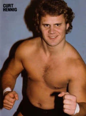 Curt Hennig，赤膊摔角手，在攝影棚中握拳微笑。 — 摔角 GIF 壁紙