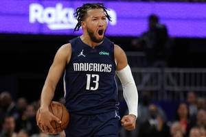 身穿獨行俠球衣的籃球運動員手持籃球慶祝。