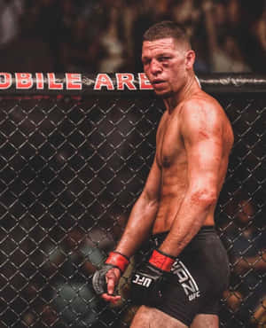 一名瘀傷的MMA選手穿著UFC裝備，在比賽後靠在八角籠上。