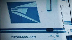 帶有藍色鷹標誌和網站文字的 USPS 送貨車
