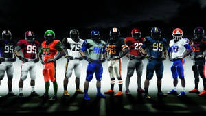 身穿隊服的足球運動員在戲劇性燈光下排成一排。 — NFL 美式足球 GIF 壁紙