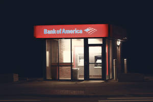 夜晚喺城市街道上亮起嘅Bank of America自動櫃員機亭。