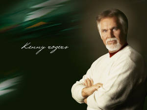 Kenny Rogers 穿著白色毛衣，交叉雙臂，站在深綠色背景前。