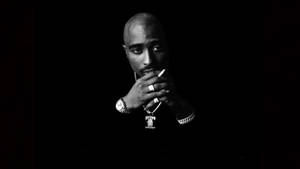 Tupac Shakur 在黑白工作室肖像中手持香煙。