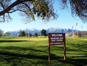 Mountain View Golf Course的歡迎標誌，背景有雪山。 — 藍天 壁紙