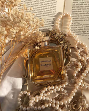 Chanel Gabrielle 香水瓶被珍珠和乾花環繞，放在一本打開的書上。