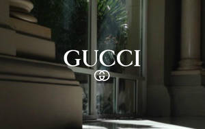 白色Gucci標誌，背景為奢華室內的大理石柱和玻璃門。