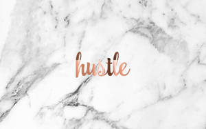 玫瑰金色草書字體的「hustle」一詞在白色大理石背景上