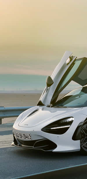 白色McLaren跑車在日落時分的海岸公路上打開鷗翼車門。 — 美學 壁紙