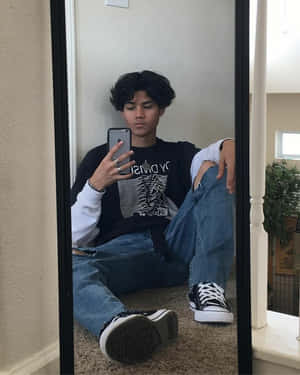 年輕男子在鋪有地毯的樓梯上穿著休閒服裝對著鏡子自拍