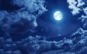 滿月透過深藍色雲層在夜空中閃耀。